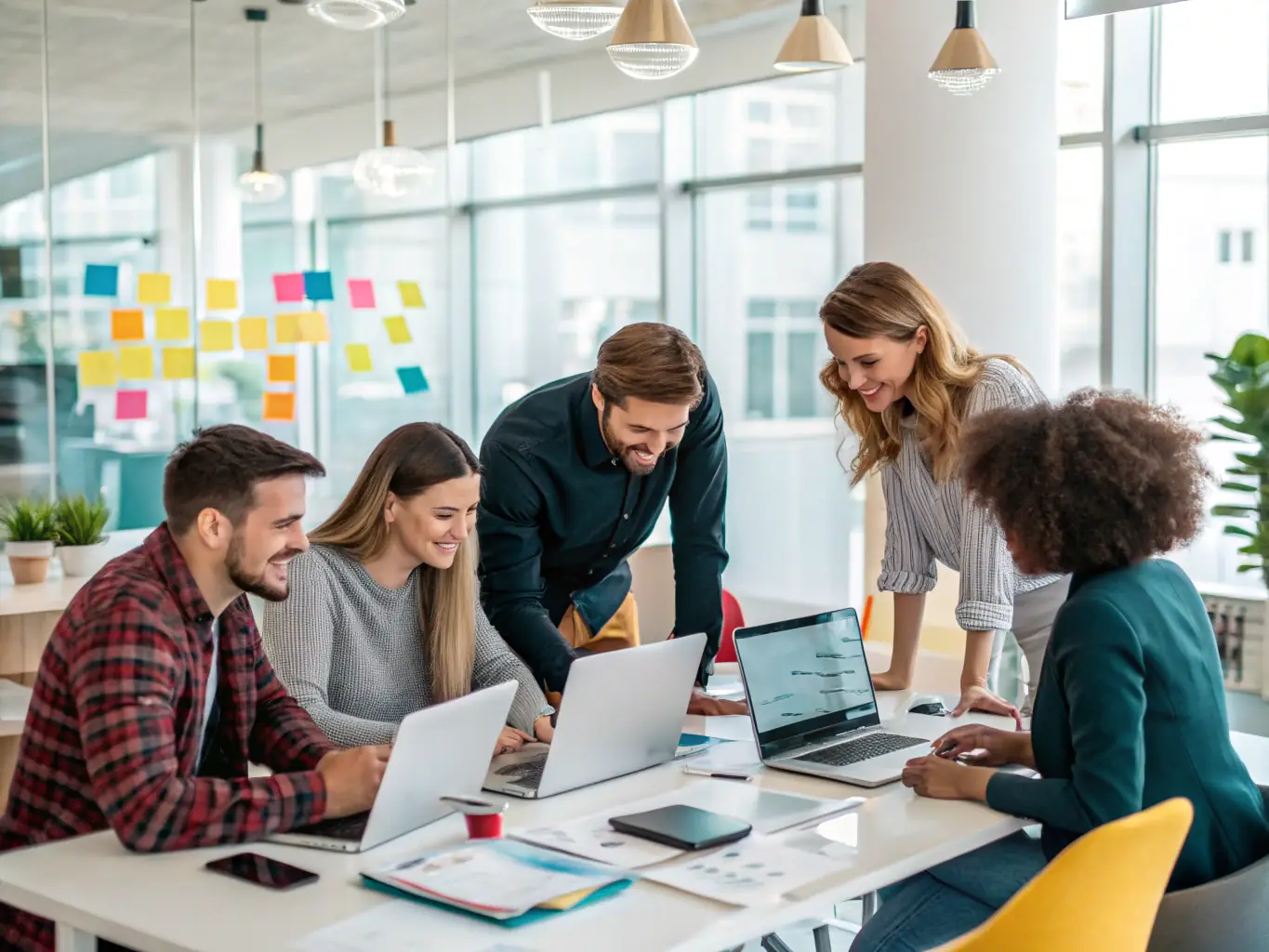 A photograph of a diverse team of AEVORATECH LTD consultants brainstorming ideas around a table filled with laptops and documents, set in a modern, collaborative workspace.